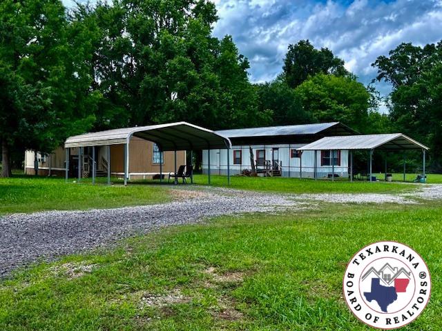 10720W.7TH Trexler Rd, Texarkana, TX 75501 - view of front of house with a detached carport, driveway, and a front yard