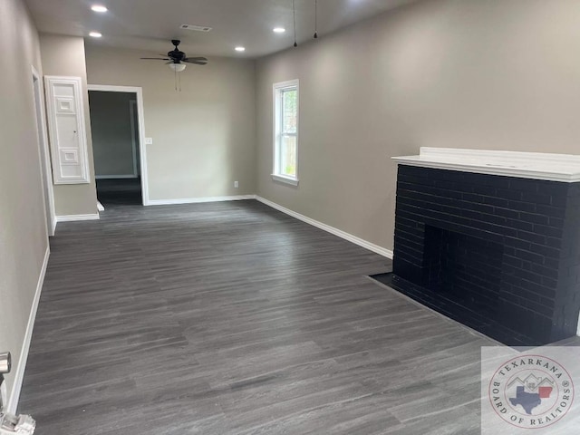 unfurnished living room featuring dark wood-type flooring and ceiling fan