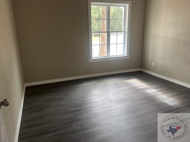 empty room with dark hardwood / wood-style flooring