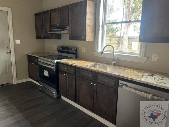 kitchen with light stone countertops, stainless steel appliances, sink, dark hardwood / wood-style floors, and dark brown cabinets