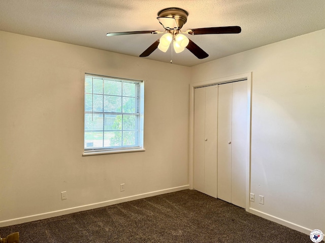 4211 Lotus Dr, Texarkana, TX 75503 - unfurnished bedroom featuring dark colored carpet, a closet, baseboards, a textured ceiling, and a ceiling fan