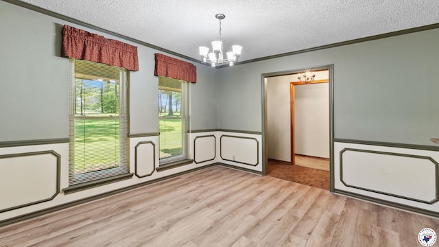 1135 Cook Rd, Texarkana, AR 71854 - unfurnished room featuring a chandelier, a textured ceiling, crown molding, wainscoting, and light wood-type flooring