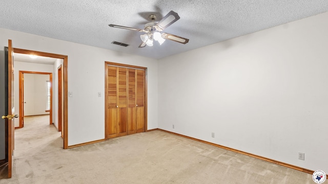 1135 Cook Rd, Texarkana, AR 71854 - unfurnished bedroom with light colored carpet, a closet, a textured ceiling, and a ceiling fan