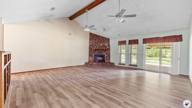 1135 Cook Rd, Texarkana, AR 71854 - unfurnished living room featuring beamed ceiling, light wood-style floors, a stone fireplace, ceiling fan, and high vaulted ceiling
