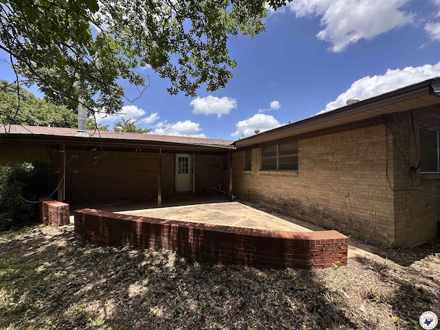 216 W Pioneer St, Wake Village, TX 75501 - rear view of house featuring a patio area and brick siding