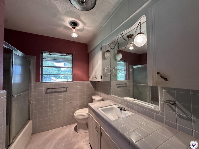 216 W Pioneer St, Wake Village, TX 75501 - full bath with tile walls, tile patterned flooring, vanity, a textured ceiling, and a wainscoted wall