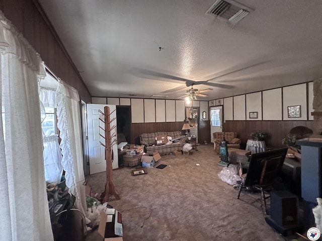 216 W Pioneer St, Wake Village, TX 75501 - living area with wood walls, ceiling fan, carpet floors, and a textured ceiling