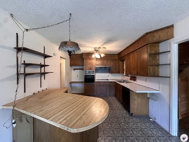 216 W Pioneer St, Wake Village, TX 75501 - kitchen with open shelves, black appliances, a peninsula, light countertops, and a textured ceiling