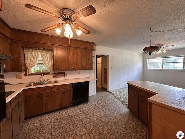 216 W Pioneer St, Wake Village, TX 75501 - kitchen with black dishwasher, light countertops, a textured ceiling, tile patterned floors, and wood walls