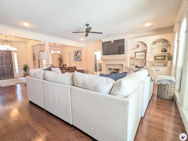 3815 Wyatt Ln, Texarkana, TX 75503 - living room with ceiling fan, crown molding, wood finished floors, a fireplace, and a chandelier