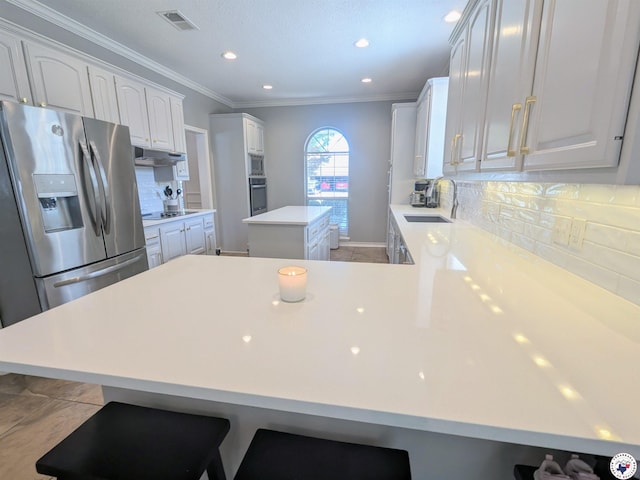3815 Wyatt Ln, Texarkana, TX 75503 - kitchen featuring appliances with stainless steel finishes, a sink, a center island, under cabinet range hood, and ornamental molding
