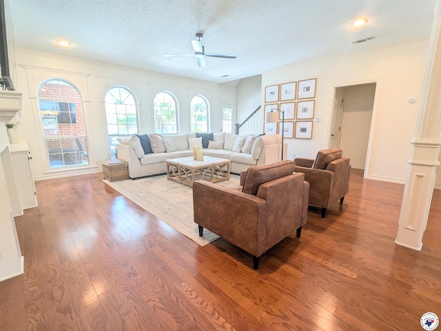 3815 Wyatt Ln, Texarkana, TX 75503 - living room with ceiling fan, stairs, dark wood-style flooring, a textured ceiling, and a fireplace