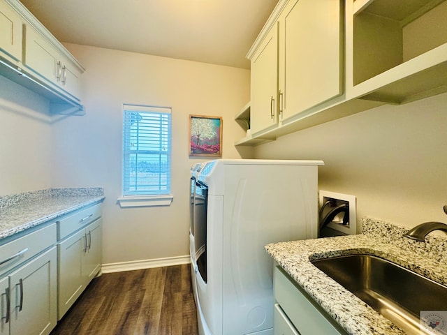 laundry room featuring baseboards, washer / dryer, cabinet space, a sink, and dark wood-type flooring