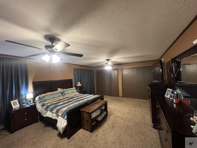 bedroom with ceiling fan, light colored carpet, and a textured ceiling