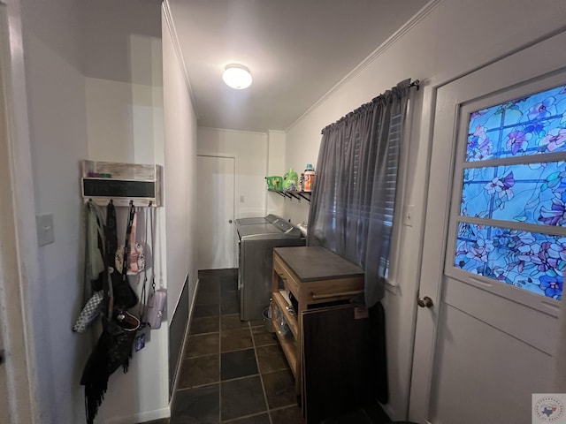 laundry area featuring crown molding, washer and dryer, and dark tile patterned flooring