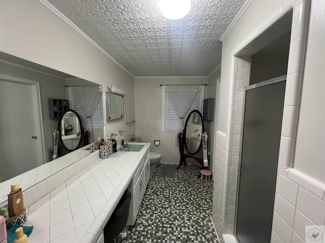 bathroom with ornamental molding, toilet, a shower with shower door, and tile walls