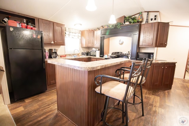 kitchen featuring a kitchen island, black appliances, light countertops, and dark wood-style flooring