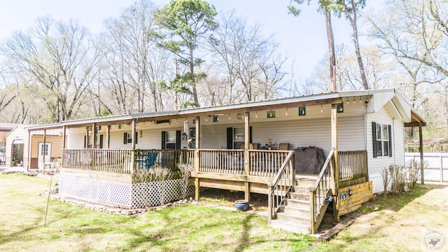 back of property featuring a lawn and covered porch