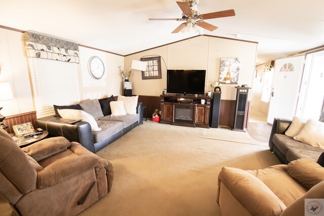 carpeted living room with crown molding, ceiling fan, and vaulted ceiling