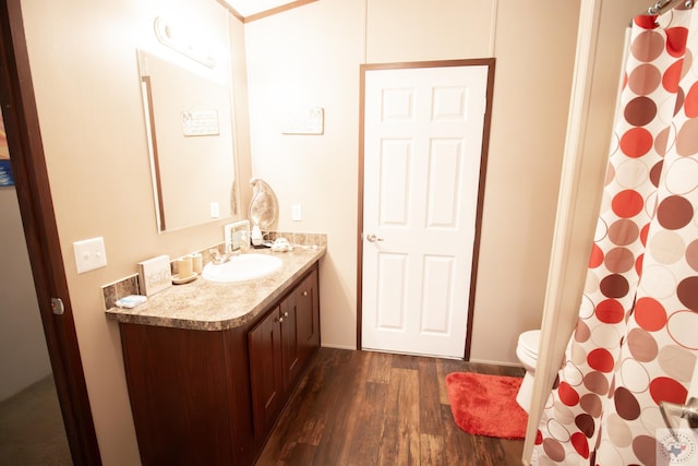 full bath featuring vanity, curtained shower, toilet, and wood finished floors