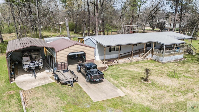 rear view of house with a detached carport, an outdoor structure, a yard, and metal roof