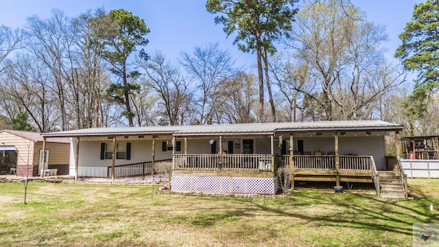 rear view of property featuring metal roof, a lawn, and a porch