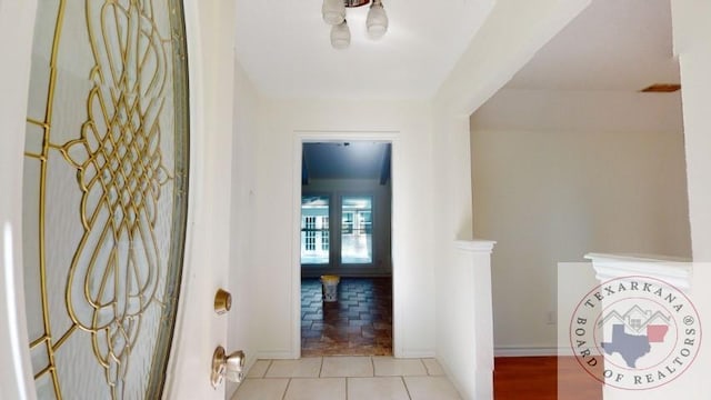 hall with light tile patterned floors