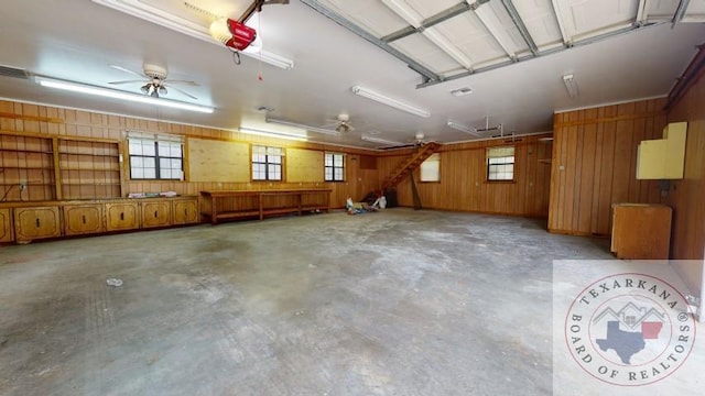 garage featuring a garage door opener and wooden walls