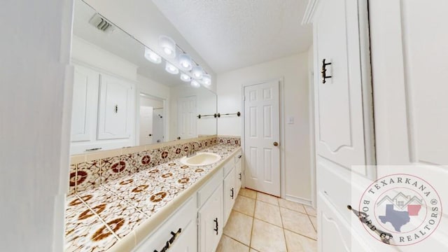 bathroom featuring a textured ceiling, tile patterned floors, and vanity