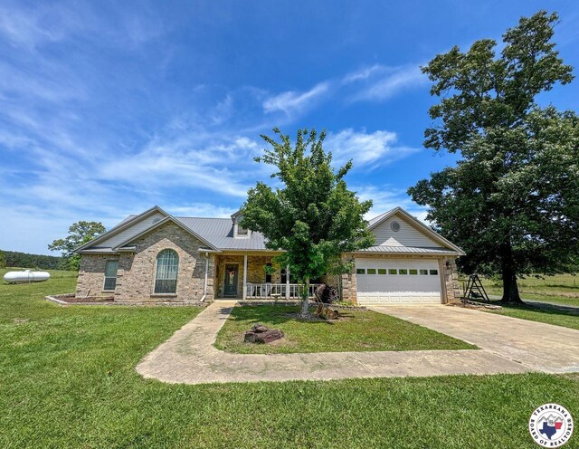 25 County Road 1905, Linden, TX 75563 - view of front facade featuring a porch, driveway, a front lawn, an attached garage, and metal roof