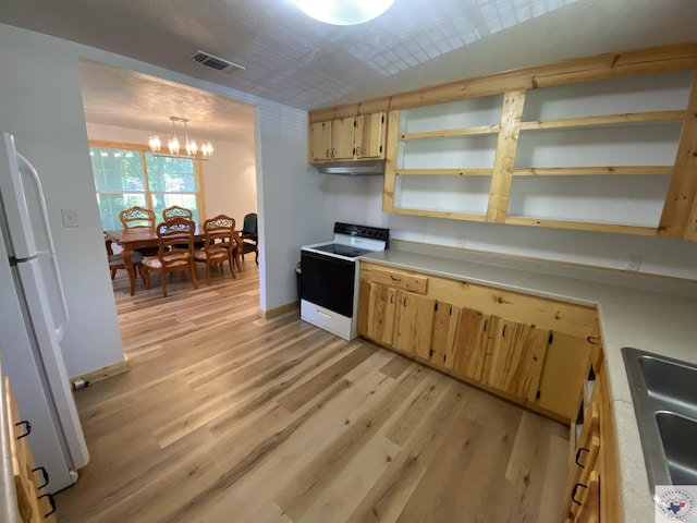 kitchen featuring range with electric stovetop, hanging light fixtures, white refrigerator, light wood-type flooring, and a notable chandelier