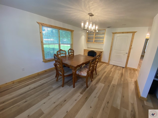 dining space featuring light hardwood / wood-style floors and a chandelier