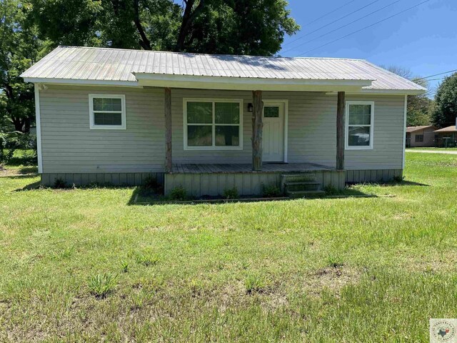 view of front of house with covered porch and a front lawn