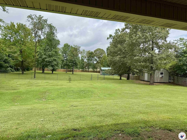 22 Heritage Blvd, Texarkana, TX 75501 - fenced backyard with a storage unit and view of wooded area