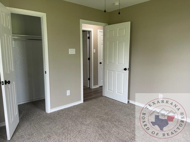 unfurnished bedroom with a closet and light colored carpet