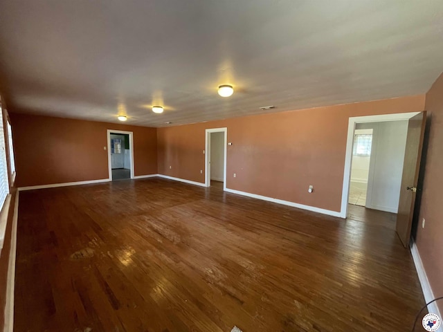 empty room featuring dark wood-type flooring and baseboards