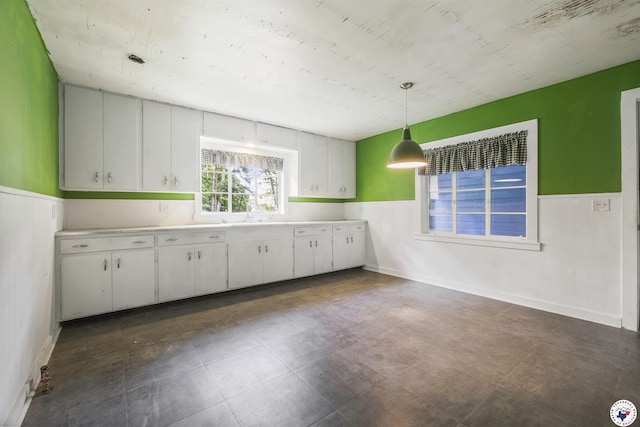 6008 E 9th St, Texarkana, AR 71854 - kitchen featuring a wainscoted wall, light countertops, decorative light fixtures, and white cabinets