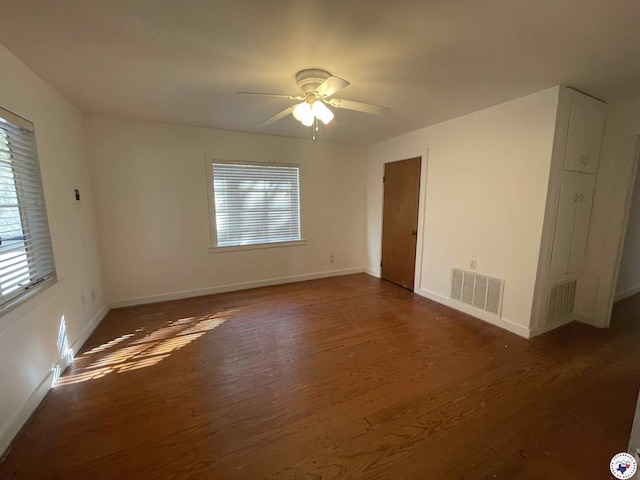 spare room with baseboards, ceiling fan, visible vents, and wood finished floors