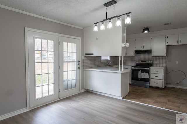 kitchen featuring decorative light fixtures, sink, electric range, and white cabinetry