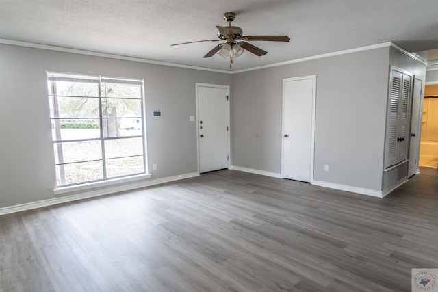 unfurnished room with ceiling fan, ornamental molding, dark hardwood / wood-style floors, and a textured ceiling