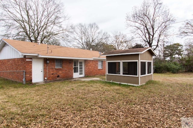 back of house with a lawn and a sunroom