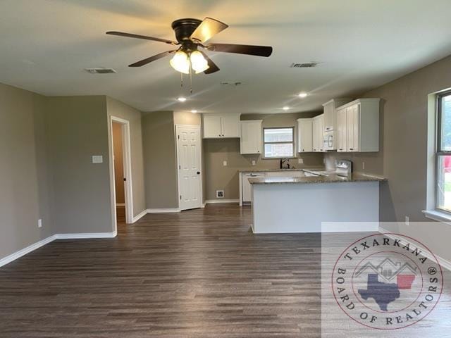 kitchen with range, white cabinetry, dark hardwood / wood-style flooring, kitchen peninsula, and ceiling fan