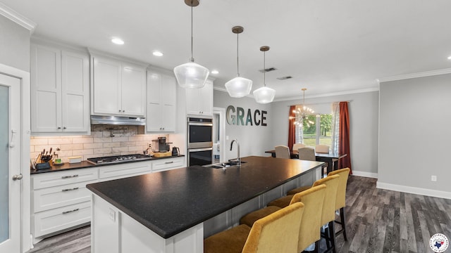 155 Lillian Ln, Texarkana, TX 75501 - kitchen with appliances with stainless steel finishes, dark countertops, dark wood-type flooring, ornamental molding, and backsplash
