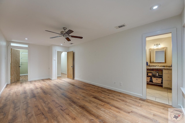 unfurnished bedroom with ceiling fan, light hardwood / wood-style flooring, and ensuite bath