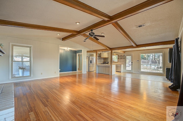 unfurnished living room featuring a textured ceiling, lofted ceiling with beams, light hardwood / wood-style flooring, and ceiling fan