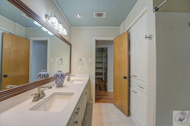 bathroom featuring a shower, tile patterned floors, vanity, and crown molding