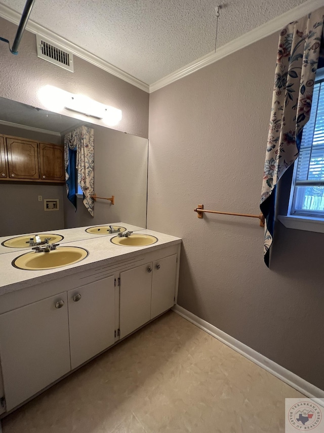 bathroom featuring crown molding, a textured ceiling, and vanity