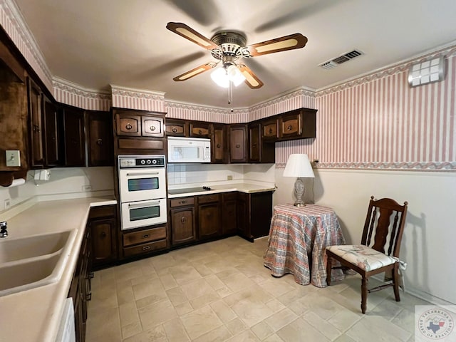 kitchen with ceiling fan, sink, white appliances, and dark brown cabinets