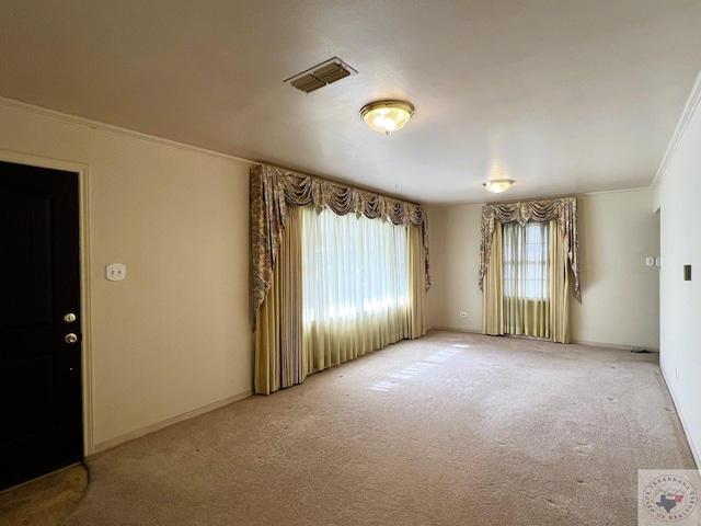 unfurnished room with crown molding and carpet