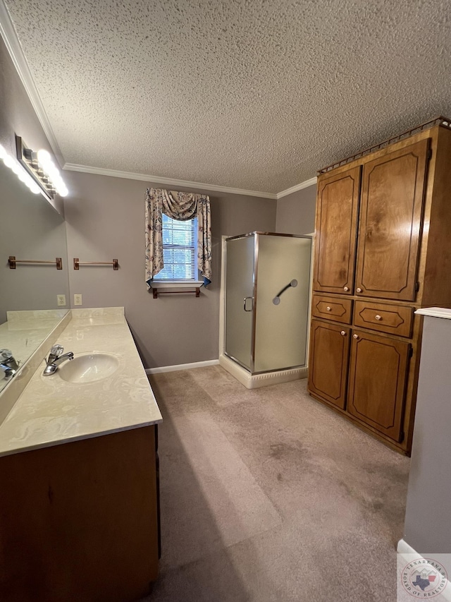 bathroom with crown molding, a textured ceiling, a shower with shower door, and vanity